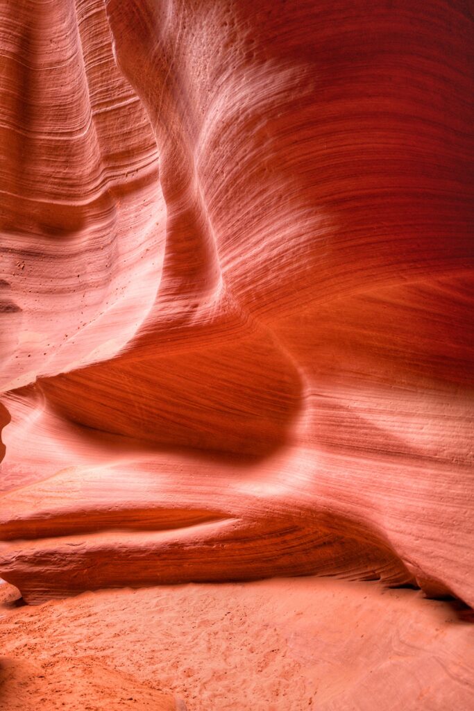 Stunning rock formation with smooth flowing surfaces and rich brown reddish hues in natural light Wallpaper