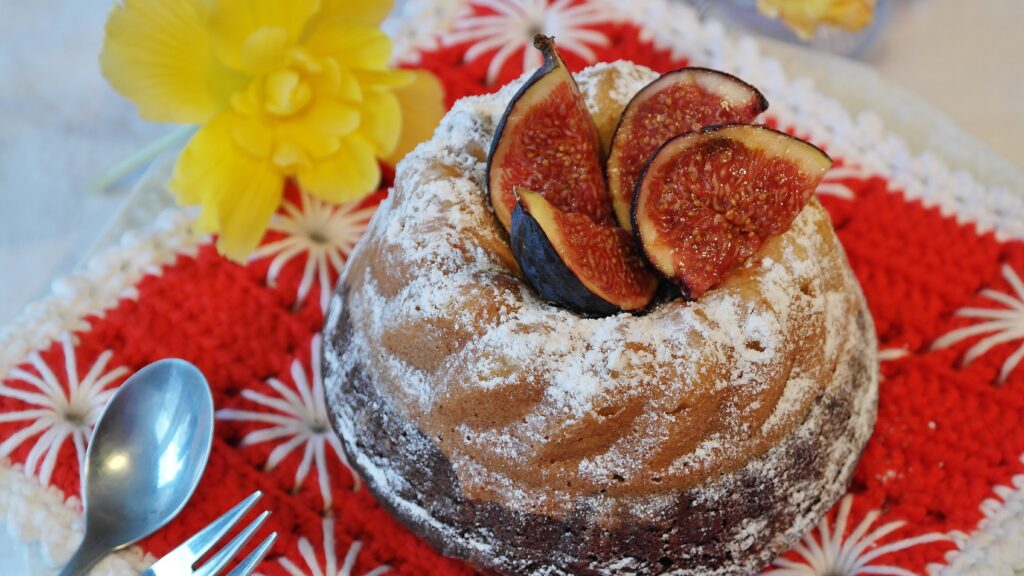Elegant Fig-Topped Cake with Flowers on Red Decorative Mat Wallpaper
