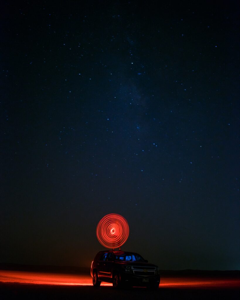 Stunning Car Wallpaper: Surreal Circular Light Under Starry Sky