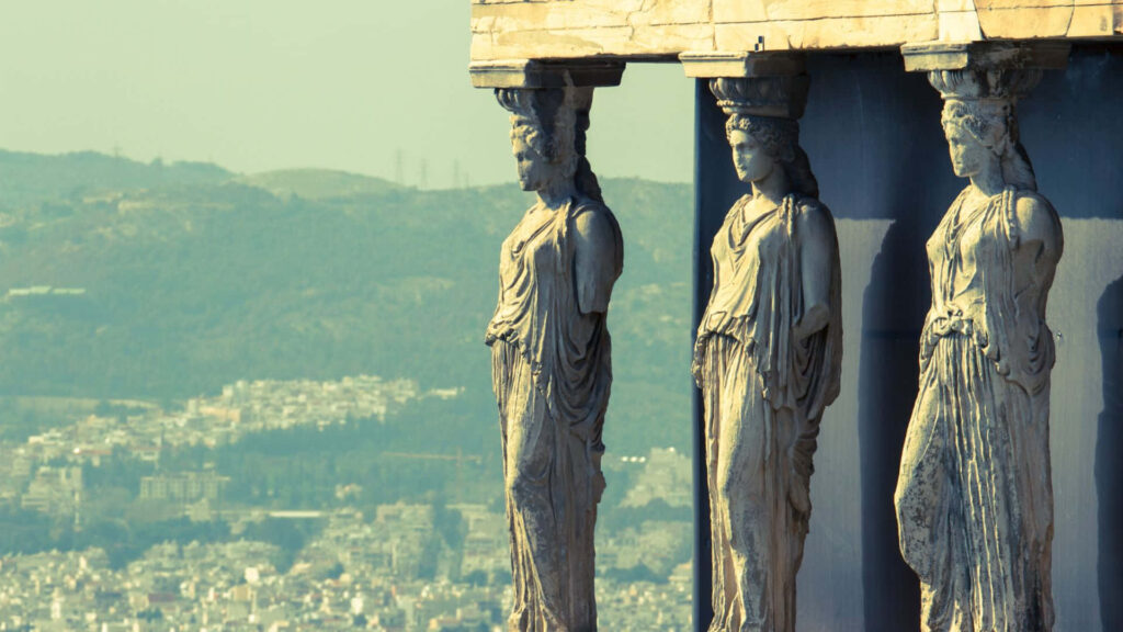 Stunning Caryatids Wallpaper: Iconic Greek Statues with City View