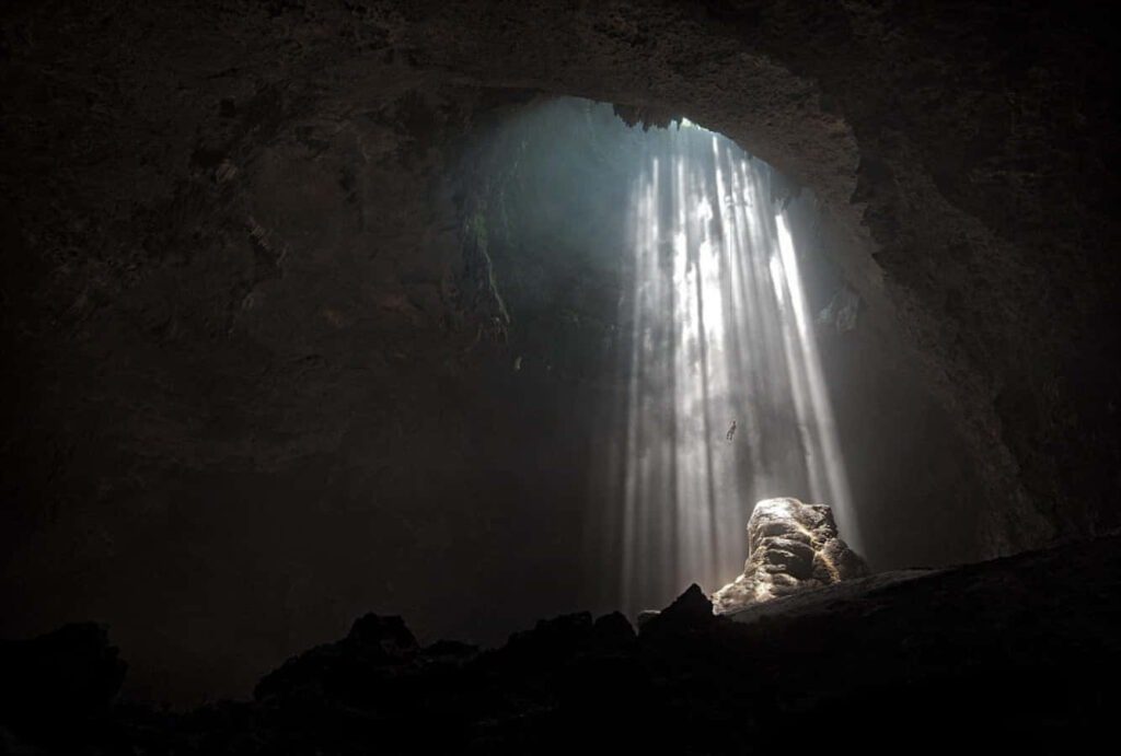 Stunning Cave Interior with Sunlight Beams: Serene Wallpaper Background
