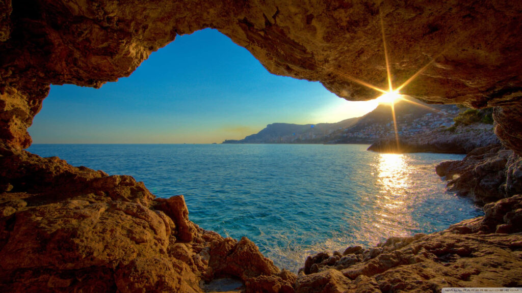 Tranquil Cave View: Sunset Over Sea - Stunning Island Wallpaper