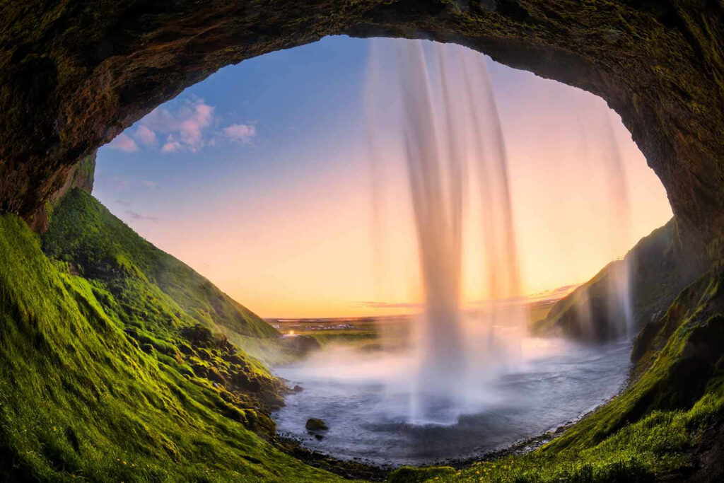 Breathtaking Cave View: Waterfall & Sunset Background Wallpaper