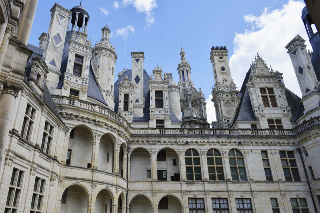 Close up of Château de Chambord Renaissance architecture with ornate spires under blue sky wallpaper