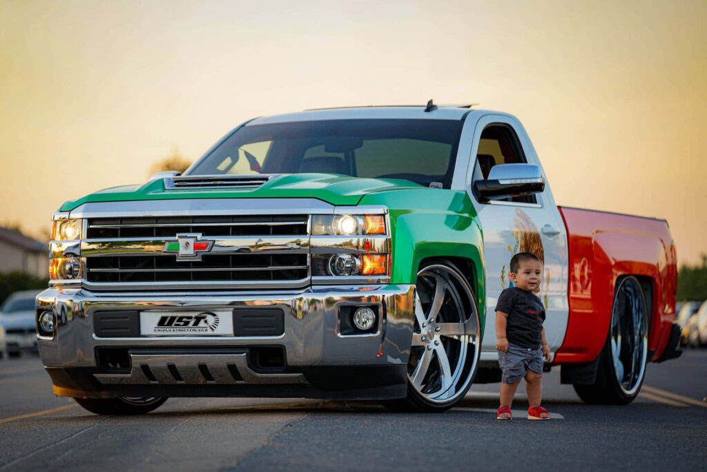 Stunning Tri-Color Chevrolet Silverado Wallpaper with Child at Sunset