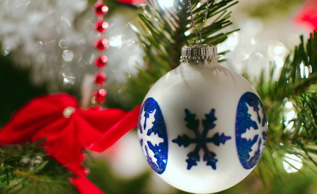 Festive Close-Up: Christmas Tree with Blue Snowflake Ornament Wallpaper