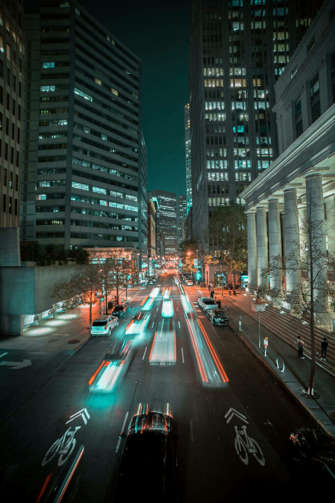 Stunning City Night View: Illuminated Road & Modern Buildings Wallpaper