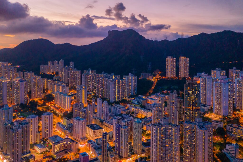 Stunning Dusk City Aerial Wallpaper with Majestic Mountain Backdrop