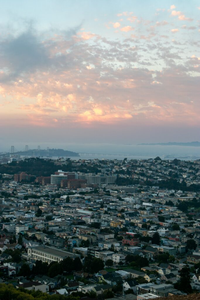 Stunning Cityscape Aerial View: Clouds, Fog & Vibrant Sunset Wallpaper
