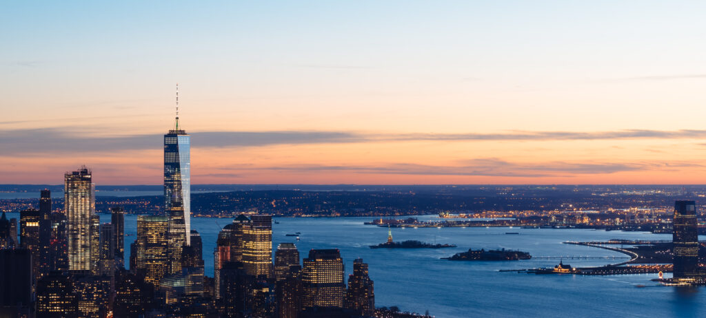 Stunning Evening Cityscape Wallpaper: Illuminated Skyscrapers & Sunset