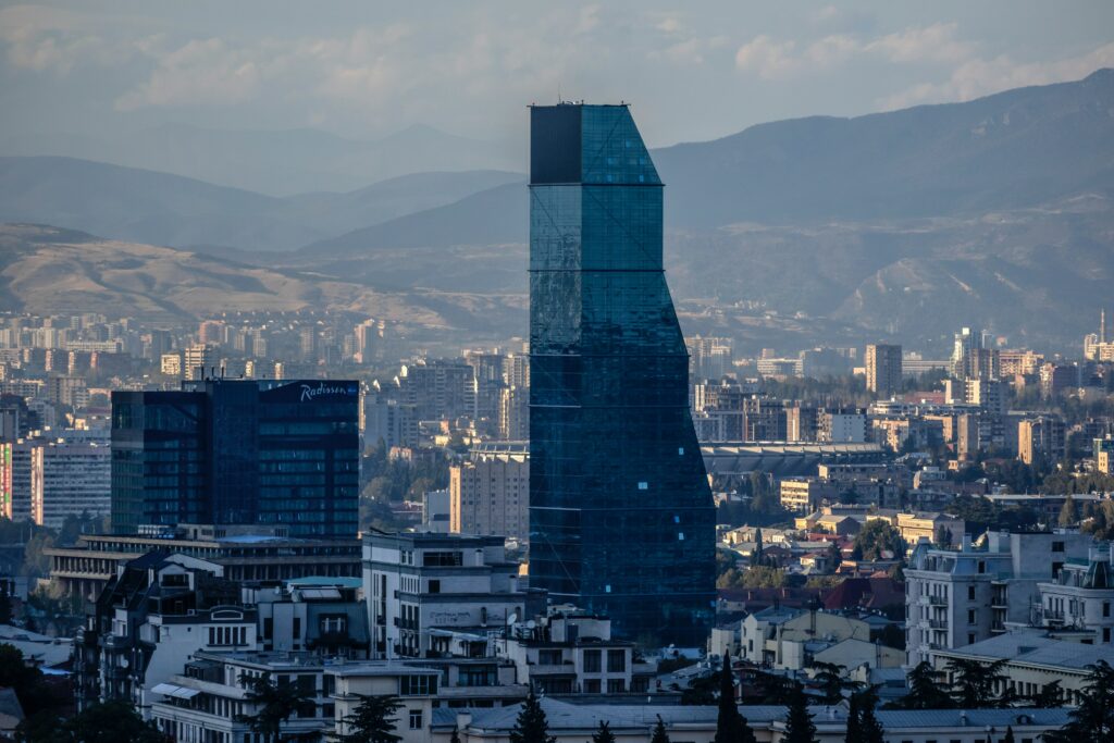 Stunning Cityscape Wallpaper: Modern Skyscraper & Serene Mountains