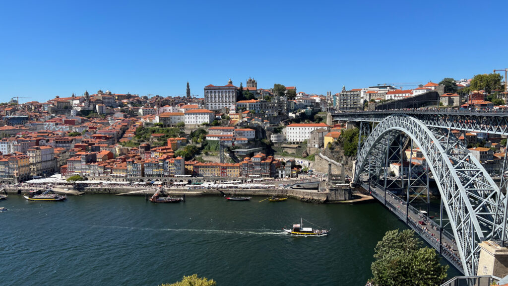Stunning Cityscape Wallpaper: River, Boats, Bridge & Colorful Hillside