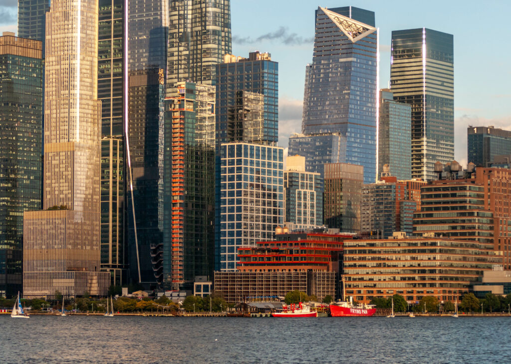 Stunning Cityscape Wallpaper: Skyscrapers, Sea & Sunlit Ships