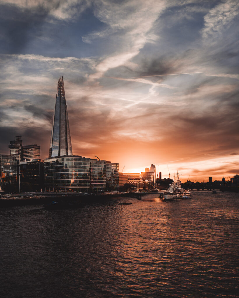 Tranquil River Embankment Cityscape Wallpaper at Sunset