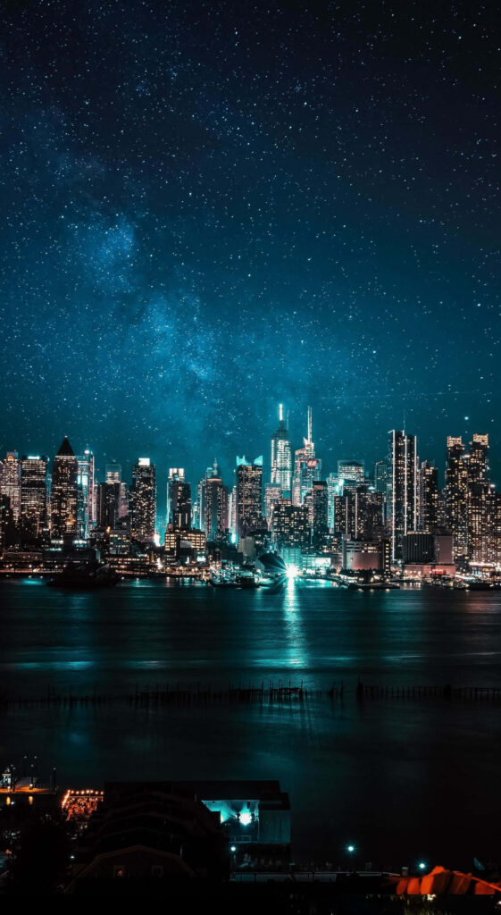 Twilight Cityscape: Glowing Lights & Serene Waters Wallpaper