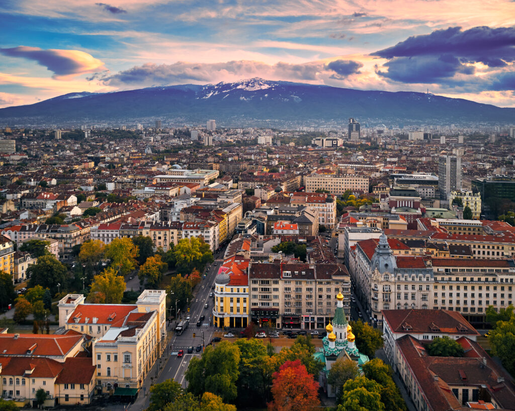 Stunning Cityscape Wallpaper: Vibrant Rooftops & Majestic Mountains