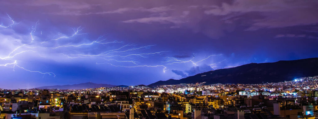 Stunning Cityscape Wallpaper: Vibrant Lightning Over Urban Mountains