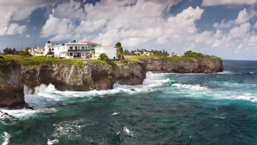 Cliffside House Overlooking Vibrant Dominican Republic Waters Wallpaper