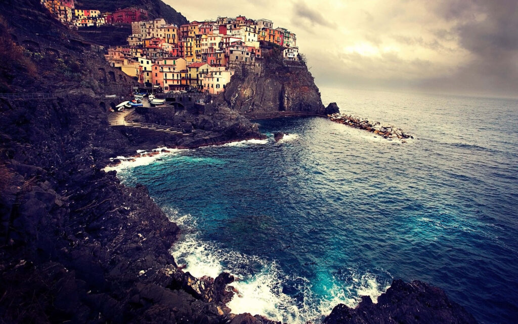 Vibrant Coastal Cityscape Wallpaper: Colorful Cliffside Homes & Ocean