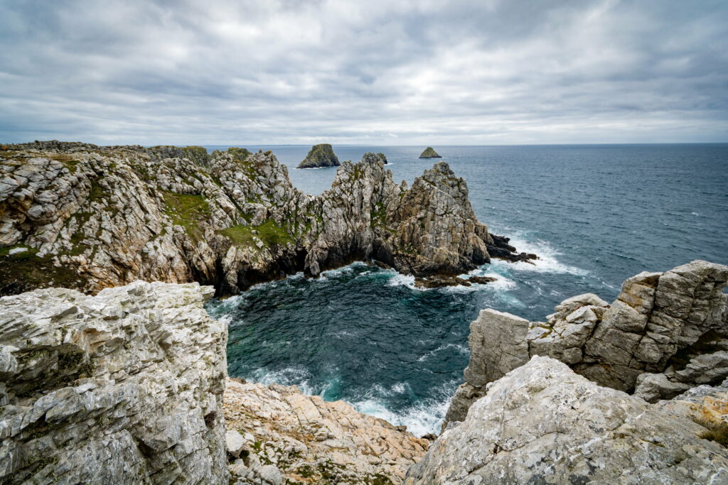 Coastal Serenity: Immersive HD Wallpaper of Majestic Rock Formation Amidst Rolling Waves and Pristine Seascape
