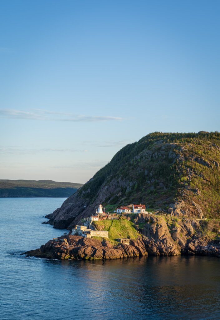Serene Coastal Landscape with Cliffs, Lighthouse, and Calm Shoreline Wallpaper