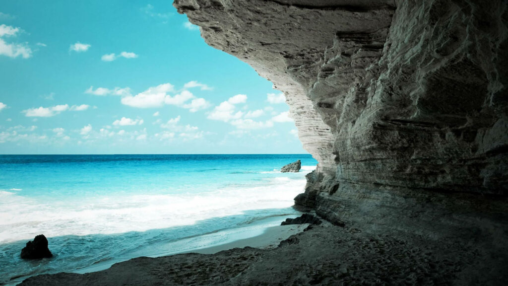 Stunning Coastal Cave Overlooking Turquoise Ocean & Sandy Shoreline Wallpaper