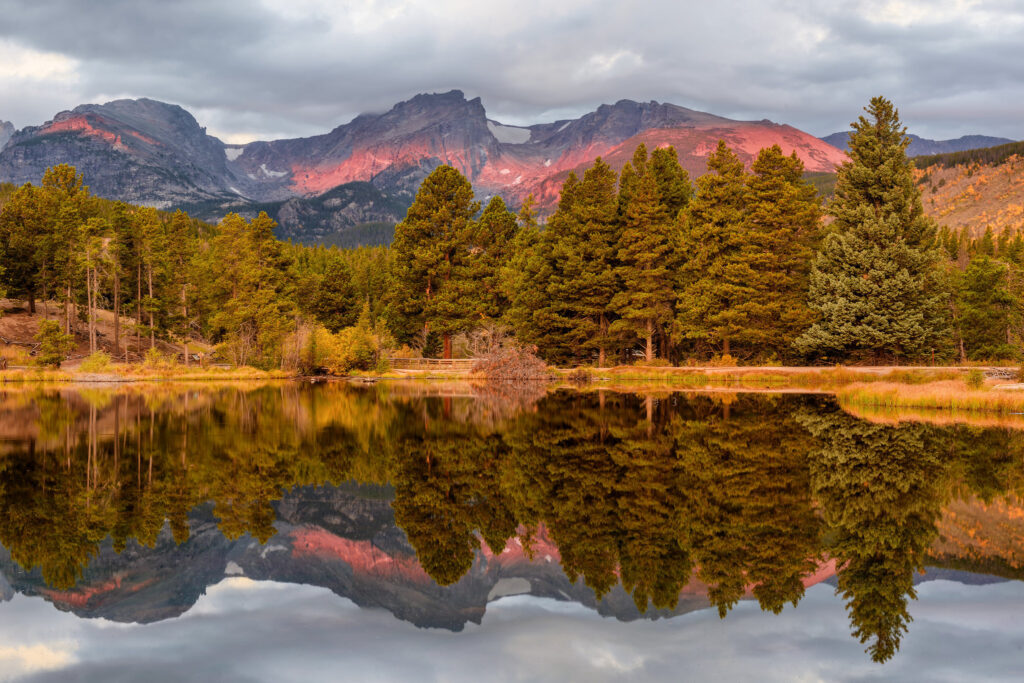 Autumn Colorado national park lake reflection with vibrant fall trees and majestic mountains background Wallpaper