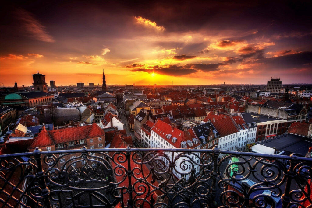 Stunning Copenhagen Sunset Wallpaper: Vibrant Rooftops from a Balcony