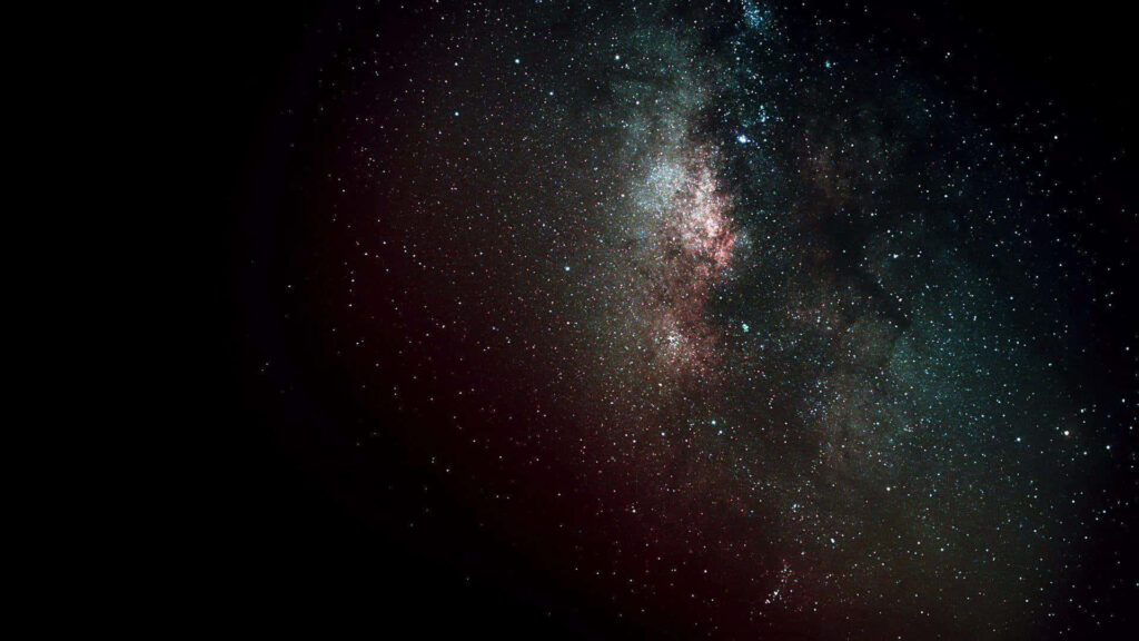 Stunning cosmic wallpaper depicting a vast universe filled with countless stars and vibrant cosmic dust in deep space.