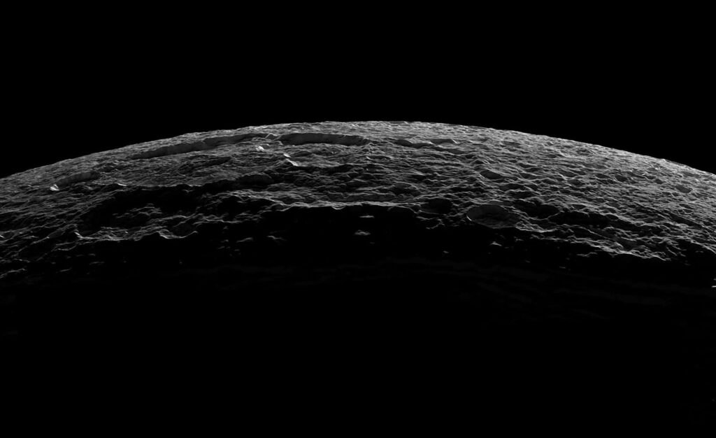Stunning cratered planetary surface bathed in soft light, with dark space backdrop. Wallpaper