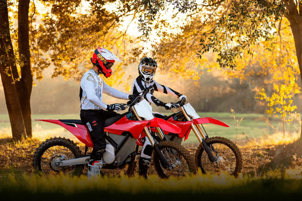 Vibrant Dirtbike Wallpaper: Riders in Golden Hour Forest Serenity