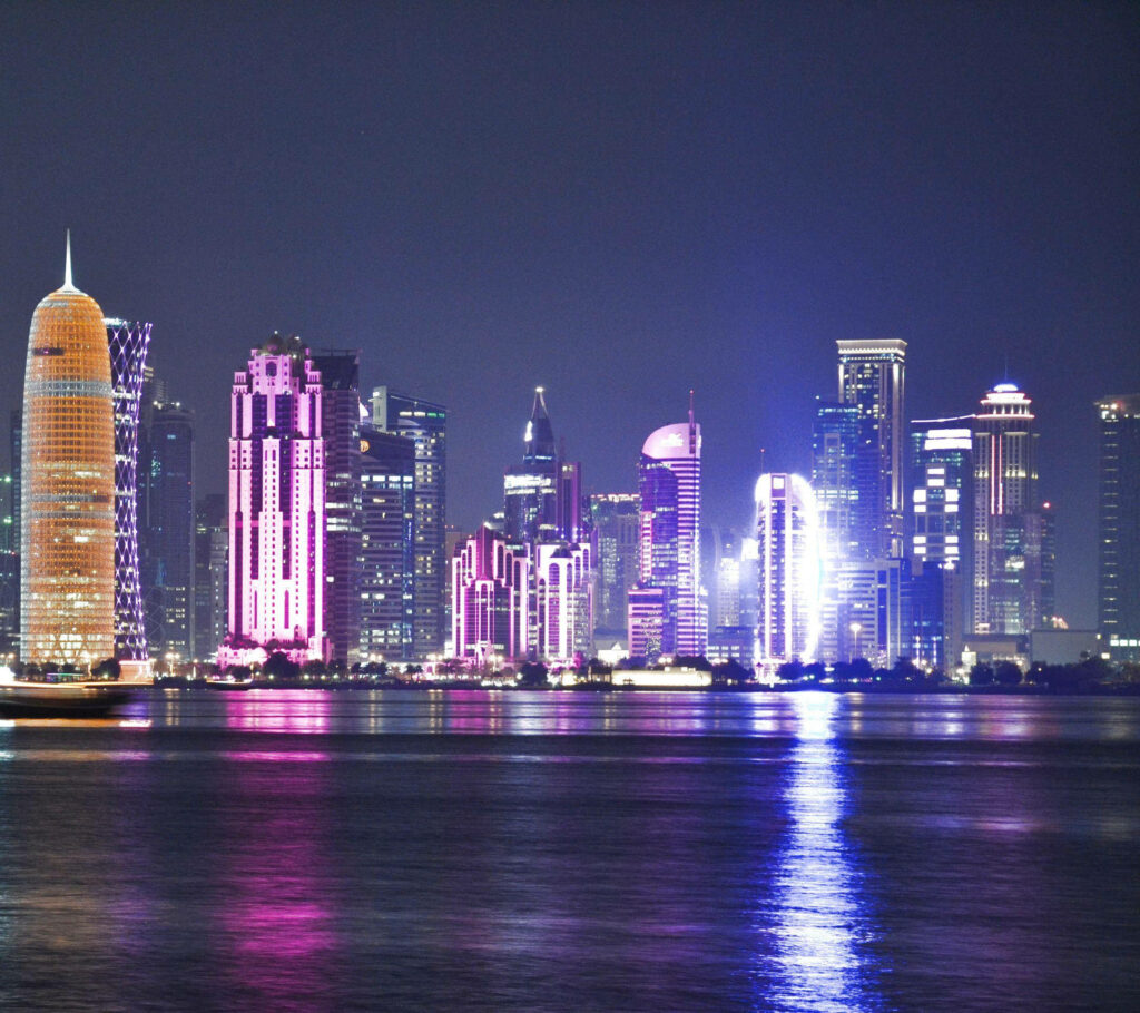 Vibrant Doha Nighttime Cityscape Wallpaper: Illuminated Skyline Reflections