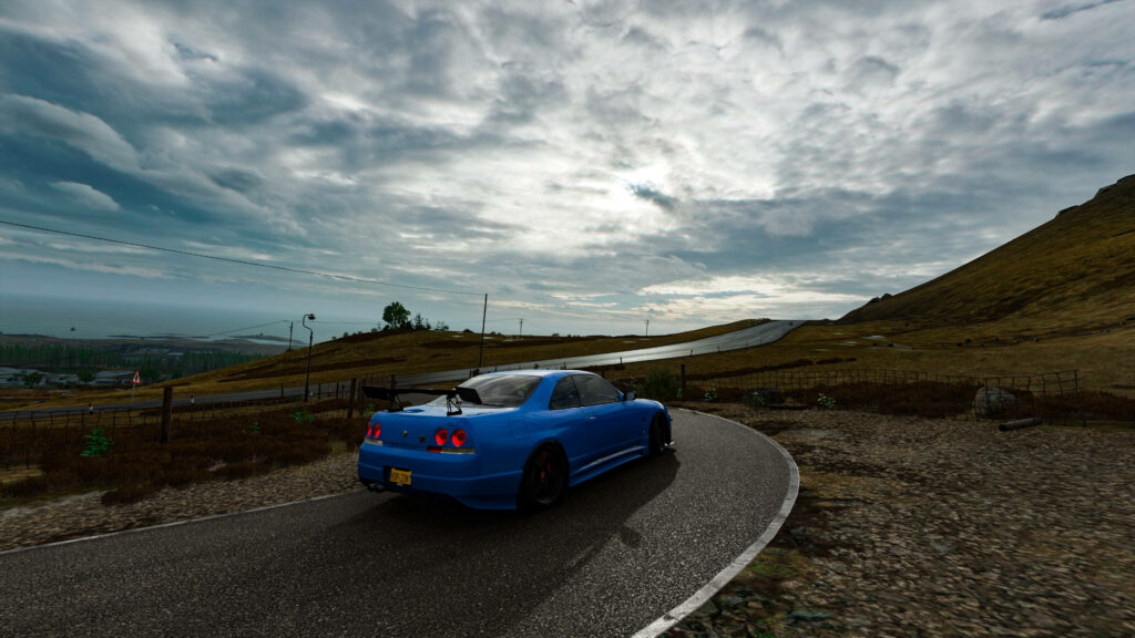 Enchanting Twilight Drive: Mesmerizing Nissan Skyline Gtr R33 on Countryside Road with an Overcast Sky Wallpaper