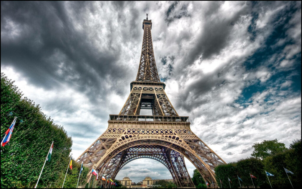 Stunning Eiffel Tower Wallpaper: Dramatic Sky & International Flags