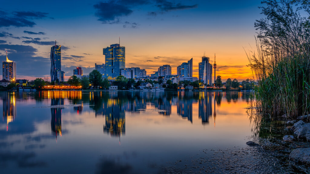 Serene Cityscape Evening Wallpaper: Modern Buildings & Sunset Reflections