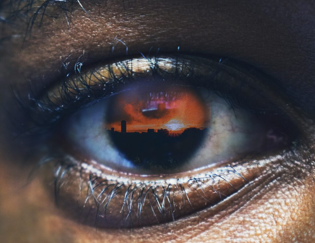 Close-Up Eye Reflection: Sunset Cityscape Wallpaper