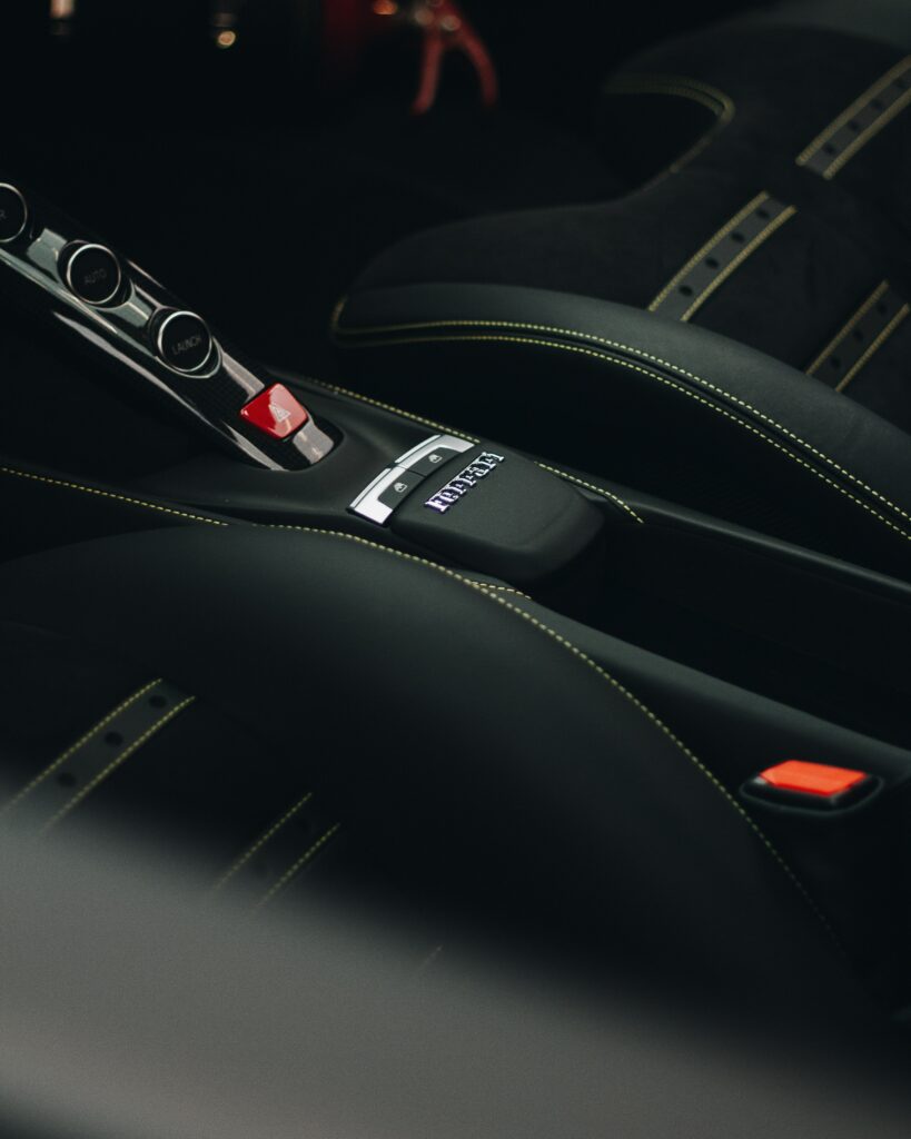 Sleek Ferrari Interior Wallpaper: Black Seats & Stylish Console