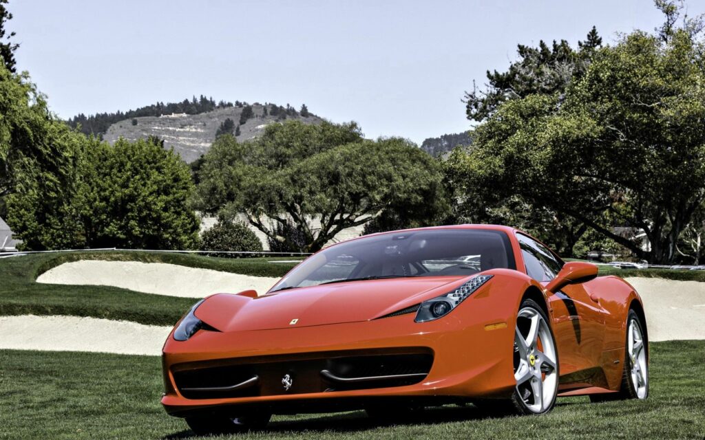 Sleek Red Ferrari Wallpaper on Lush Green Field and Clear Sky