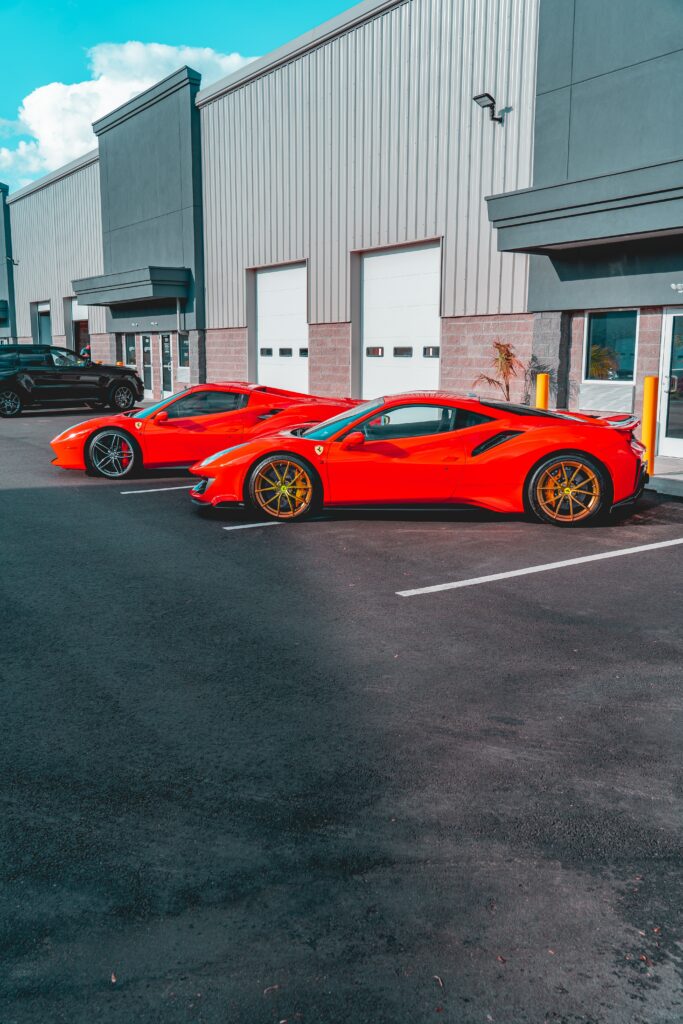 Stunning Red Ferrari Sports Cars in Front of Modern Architecture Wallpaper
