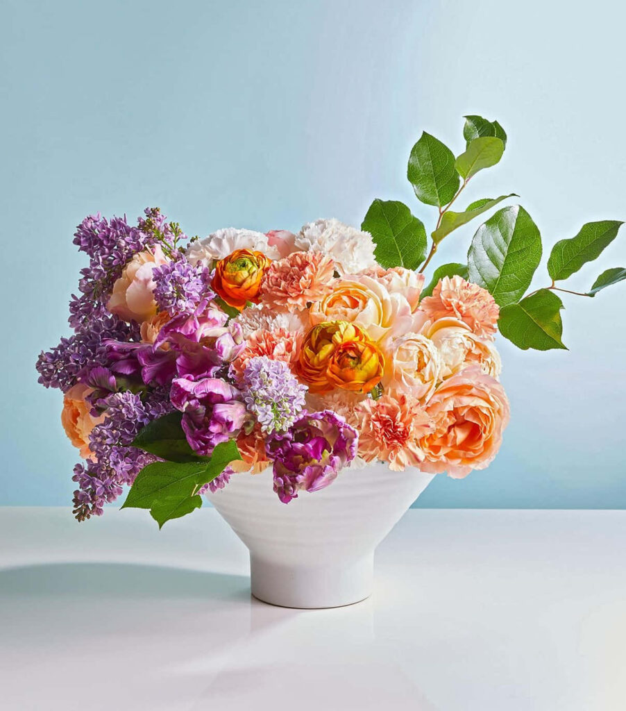 Elegant Floral Wallpaper: Vibrant Roses in a White Vase on Blue