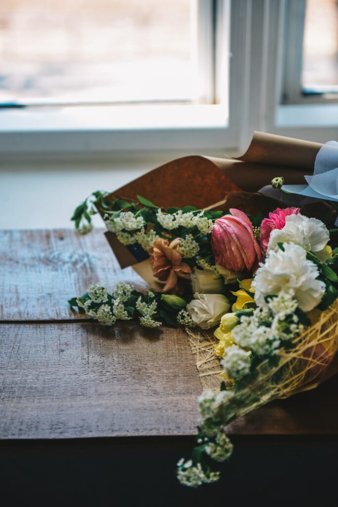 Vibrant Flower Bouquet Wallpaper on Rustic Wood by Sunlit Window