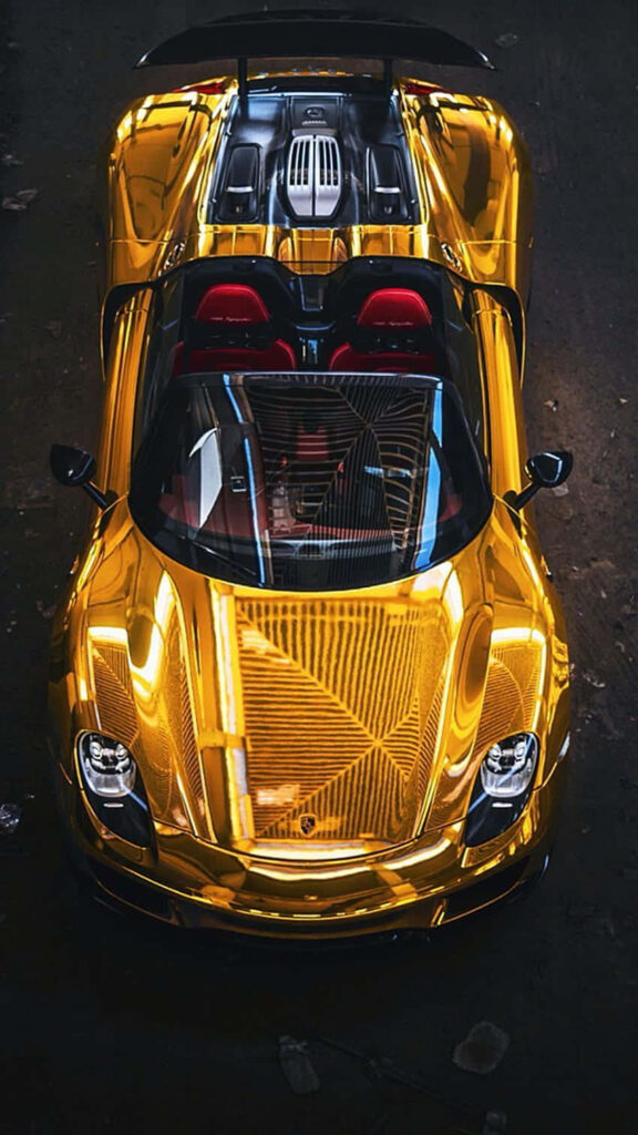 Gold Porsche with transparent rear panel under dramatic lighting showcasing sleek design luxury Wallpaper