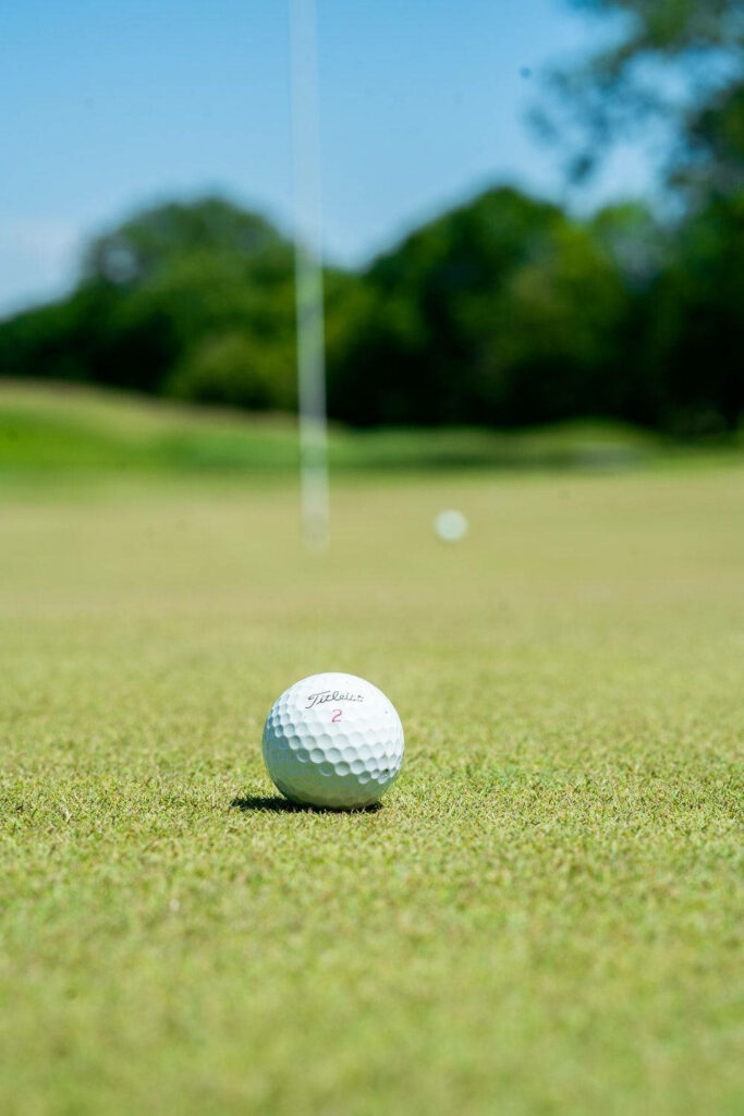 Stunning Golf Ball Wallpaper: Close-Up on Lush Green Course