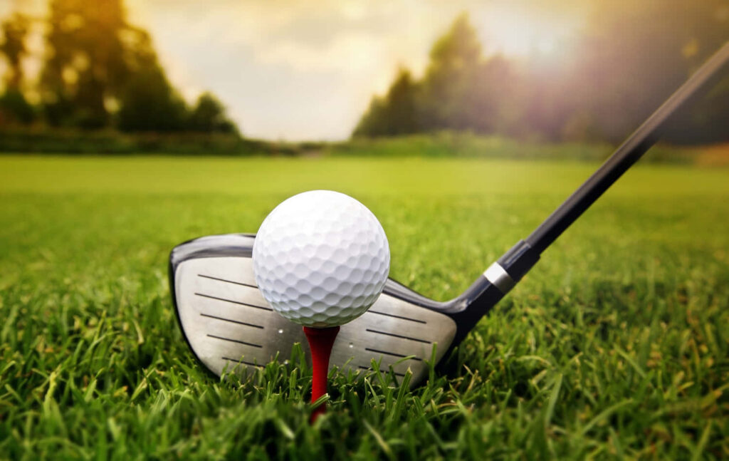 Golf Ball on Red Tee with Club: Serene Sunset Course Wallpaper
