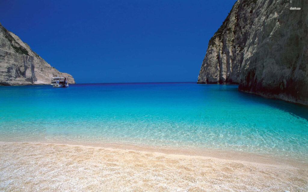 Stunning Greek Beach Sunset Wallpaper: Turquoise Sea & Cliffs