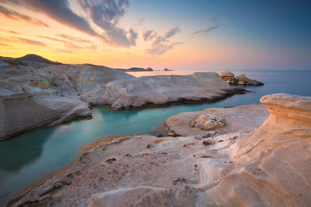 Stunning Greek Coastal Sunset Wallpaper: Rocky Cliffs & Turquoise Waters