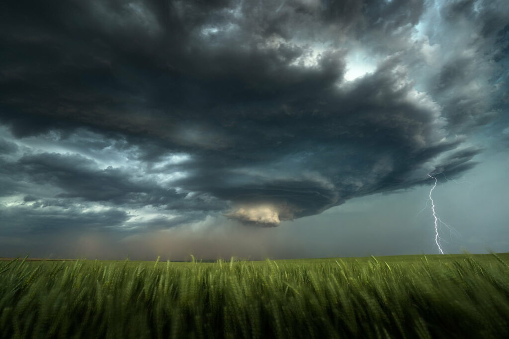 Stunning HD Storm Wallpaper: Dark Clouds & Lightning Over Green Field