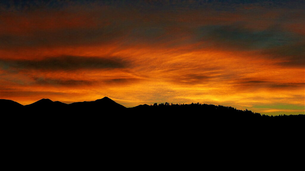 Dramatic Sunset HD Wallpaper: Vibrant Clouds & Mountain Silhouette