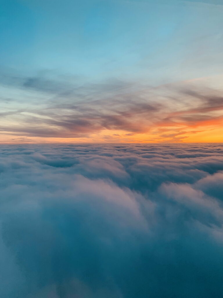 HD Wallpaper: Serene Sunset Over Fluffy Clouds in Vibrant Blues