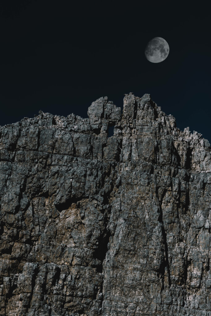 Serene Cliffside Night Sky Wallpaper with Moon Glow - HD Background